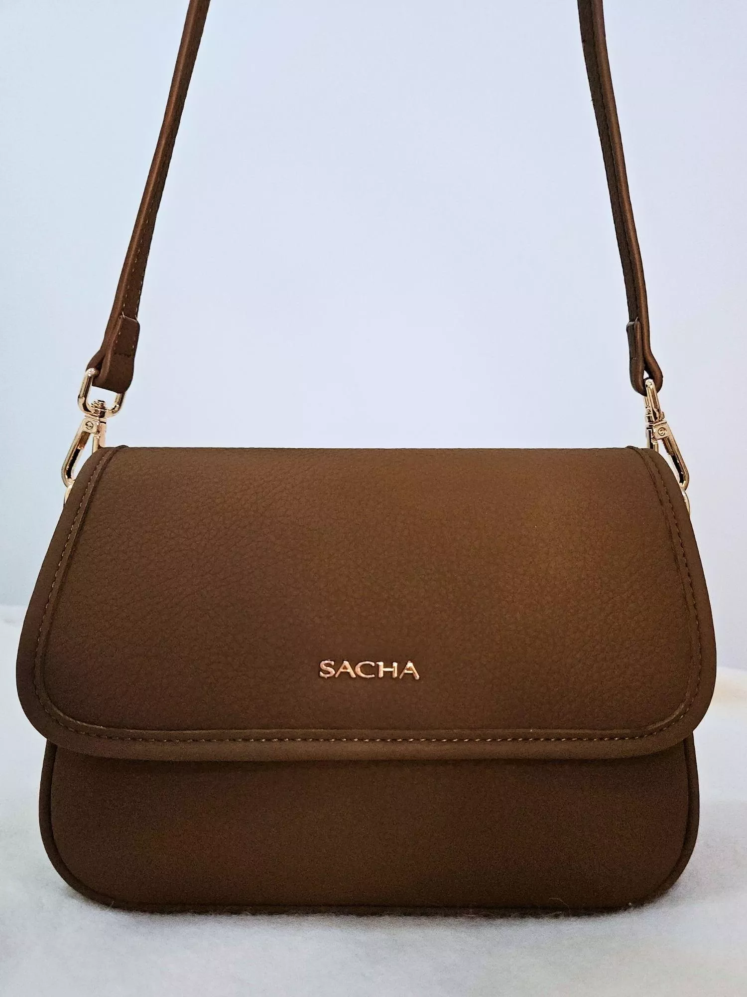 【YZGM羽之共鳴服飾《微光扉頁》簡約翻蓋方包（黃咖啡/深棕色）】  平滑細膩的皮革面料，在光線下呈現內斂的溫潤光澤。 沒有多餘裝飾，僅以精緻金屬字樣點綴 完美詮釋「極簡即是美」的穿搭哲學  ✨ 商品亮點 ．極簡翻蓋設計，俐落且具現代感 ．平滑細膩皮革，手感紮實有型 ．金屬標誌細節，提升視覺層次 ．經典方正包型，輕鬆駕馭各種場合  穿搭建議： 都會通勤 / 文青風格 / 俐落西裝 / 日常穿搭