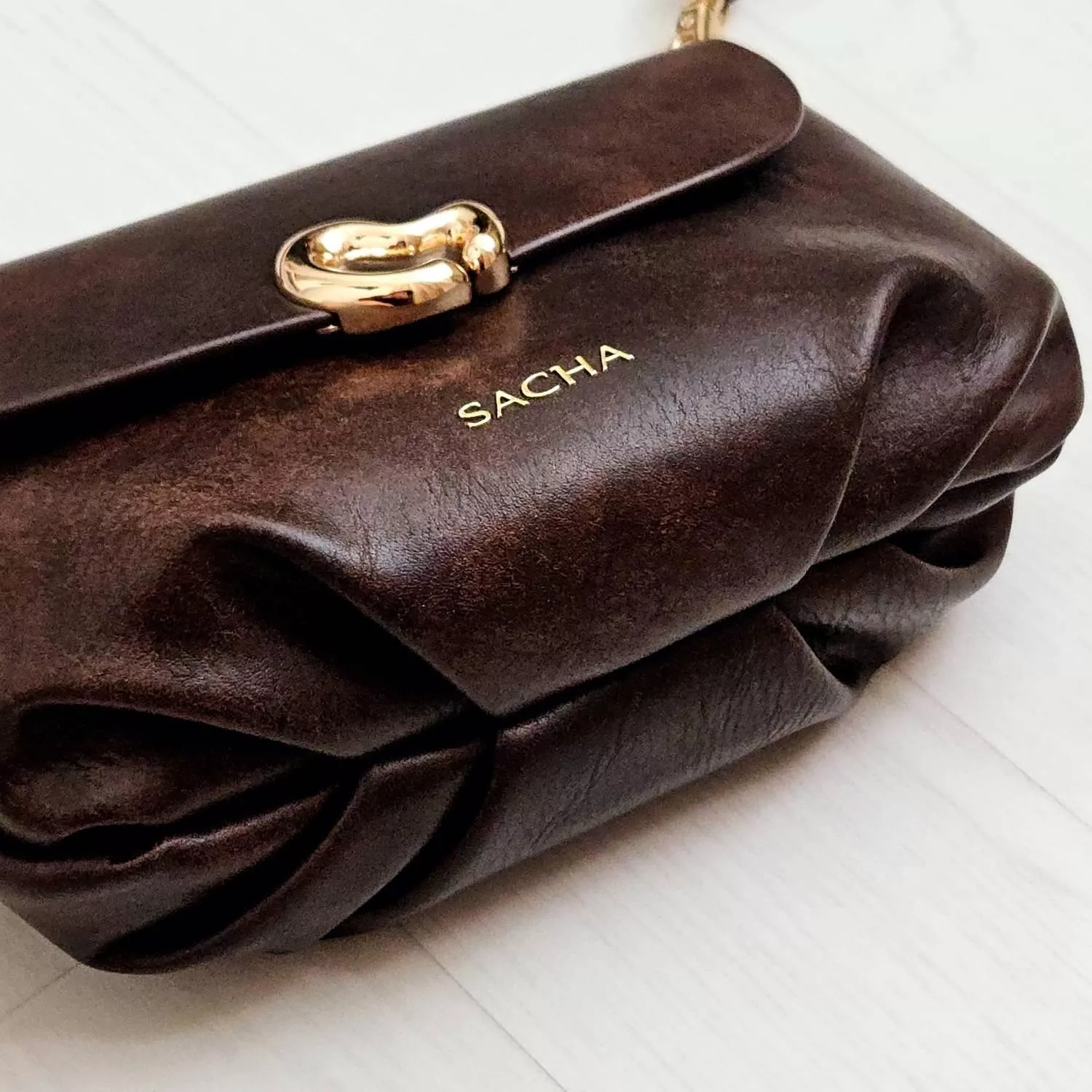 【YZGM羽之共鳴服飾《深焙可可》復古揉紋心形釦飾包】  迷人的醇厚色澤結合復古揉捻紋理 皮革表面細微的紋路變化，賦予包包一種如古董珍藏般的歲月韻味 流線型的心形金屬釦環，演繹著優雅且不羈的浪漫情懷  ✨ 商品亮點 復古皮革揉紋，每一面都獨具質感 特殊流線心鎖釦，點綴亮點細節 圓潤包身曲線，好收納隨身物品   【商品資訊】 顏色： 深咖啡色 尺寸：22 &times; 9 x 14 公分（長x寬x高） 材質：人造皮革 閉合型式 ：磁吸釦+拉鍊 製造：馬來西亞 Malaysia