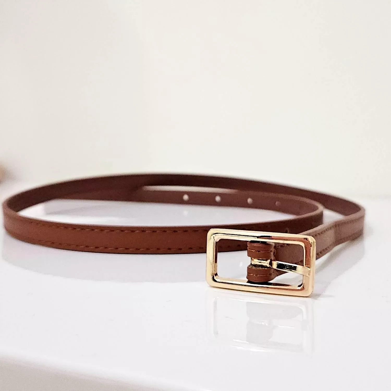 【YZGM羽之共鳴服飾《焦糖暮色》金屬方釦細腰帶】  如濃郁焦糖般的醇厚色澤，搭配簡約質感的金色方釦 細緻的皮革紋理襯托出腰間的纖細感，於簡約中勾勒出優雅輪廓 是穿搭中不可或缺的沈穩點綴  ✨ 商品亮點 經典焦糖色系，百搭不退流行 細緻皮革手感，耐用且優雅 亮面金屬方釦，增添高級質感 修飾身型比例，點亮整體層次  穿搭建議： 高腰西裝褲 / 長版洋裝 / 針織長裙 / 職場穿搭  【商品資訊】 顏色：焦糖色 尺寸：101 x 1 公分（長x寬） 材質：人造皮革 製造：馬來西亞 Malaysia