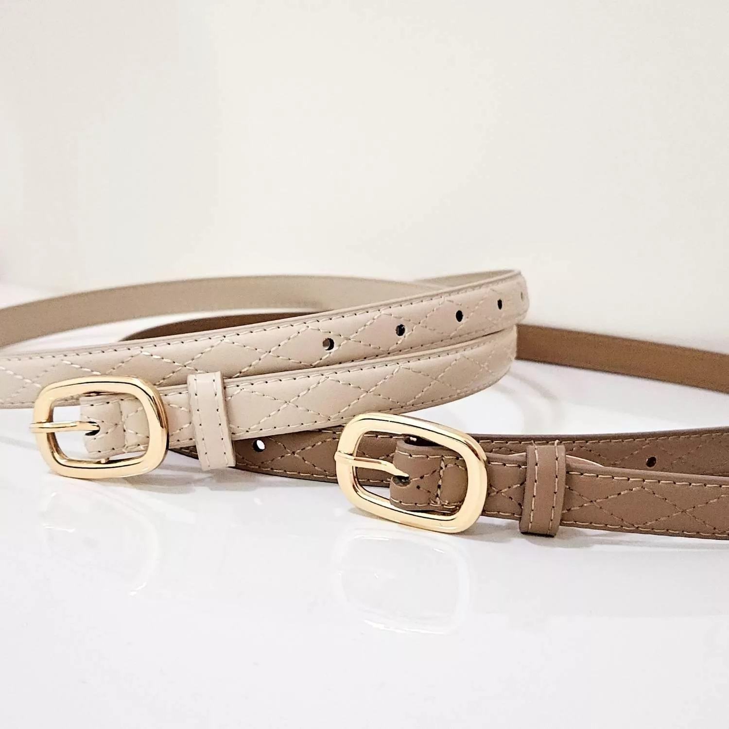 【YZGM羽之共鳴服飾《奶茶格紋》金屬圓釦菱格腰帶 (深奶茶色/淺奶茶色)】  溫潤的奶茶色調揉合優雅的菱格壓紋，在光影下呈現細膩的立體層次 精緻的金色圓釦圓潤大方，讓日常穿搭瞬間充滿精緻細節  ✨ 商品亮點 菱格壓紋工藝，質感加倍 溫柔奶茶色，與大地色系完美融合 圓潤金屬釦環，柔化腰線視覺 顯瘦度極佳的細帶設計  穿搭建議： 格紋西裝外套 / 毛呢裙 / 復古洋裝 / 法式浪漫風  【商品資訊】 顏色：深奶茶色/淺奶茶色 尺寸：106.6 x 1.8 公分（長x寬） 材質：人造皮革 製造：馬來西亞 Malaysia