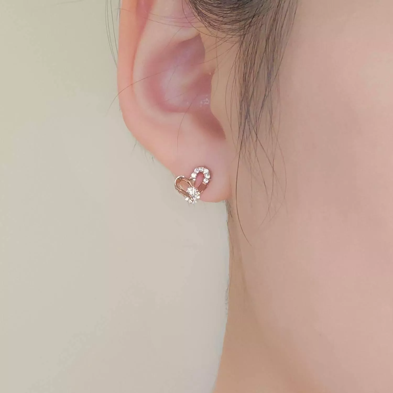 優雅的玫瑰金線條勾勒出鏤空心形， 一側鑲嵌細密的閃鑽，中心點綴一顆奪目的鋯石 簡約卻充滿力量感，演繹著輕奢的現代美學  ✨ 商品亮點 經典鏤空心形，時髦耐看 玫瑰金鍍層，襯托亞洲膚色 主石閃耀吸睛，修飾臉型 正式場合與日常約會皆適配  穿搭建議： V領襯衫 / 小黑裙 / 晚宴 / 商務餐敘 / 情人節約會  【商品資訊】 ．耳針材質 ：低敏S925銀針 ．商品材質 ：鋯石(蘇聯鑽)、厚鍍14k金 ．Size 尺寸 ：1.2 x 0.7cm ．一對販售
