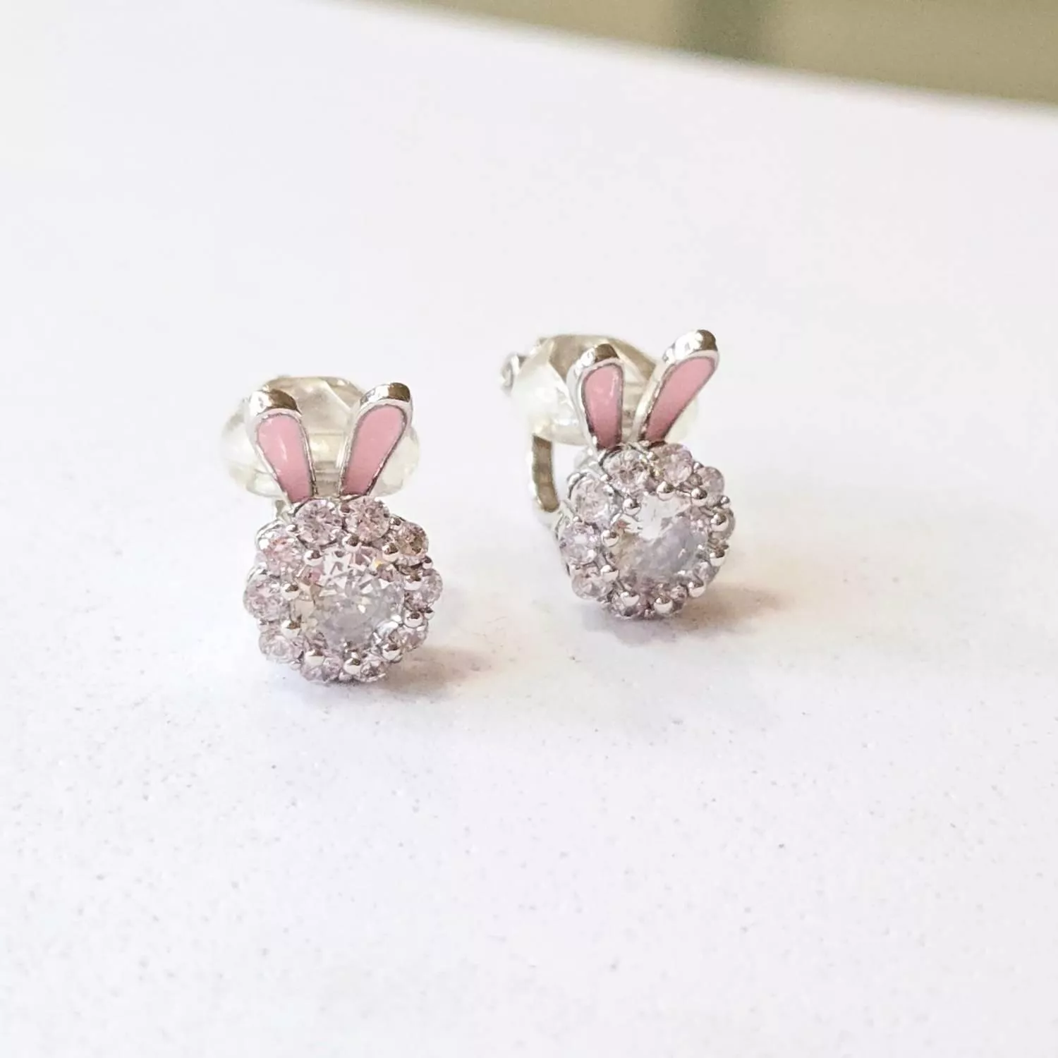 晶瑩剔透的大顆鋯石被一圈細鑽簇擁 上方躍出一雙俏皮的粉色兔耳 閃爍著靈動而華麗的光澤 讓舉手投足間充滿驚喜感  ✨ 商品亮點 立體粉色兔耳，甜美度爆表 滿鑽圍繞設計，極致閃耀 可旋轉的鋯石水鑽，更加靈動可愛 輕量化設計，長時間佩戴無負擔  穿搭建議： 露肩上衣 / 甜美公主風 / 派對聚會 / 俏皮雙馬尾  【商品資訊】 ．耳夾材質 ：低敏S925銀 ．商品材質 ：鋯石(蘇聯鑽) ．Size 尺寸 ：1.4 x 0.8cm ．一對販售