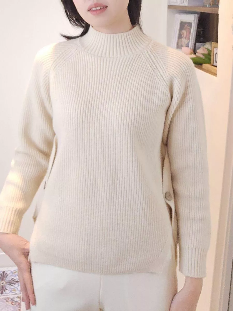 《霧色詩篇》側開叉木鈕扣高領針織上衣 &mdash;&mdash; 如晨霧般輕柔，將慵懶與詩意穿在身上。 &mdash;&mdash;  【設計細節：低調而不平庸】 側擺處加入了細膩的開叉設計與質感木鈕扣，打破了傳統針織衫的沉悶感。 側邊的線條延伸能巧妙地修飾腰臀曲線，無論是自然垂墜或是將前襬紮入長裙，都能呈現極具層次感的視覺效果。  【產品亮點】 溫潤色澤： 奶油般的霧白色調，襯托亞洲女孩的膚色，讓妳在冷色調的冬日裡自帶溫柔光圈。 黃金比例高領： 恰到好處的立領高度，保暖卻不勒脖，完美修飾頸部線條。 微寬鬆修飾剪裁： 慵懶的廓形設計，藏起腰間肉肉，給妳最自在的包裹感。 細膩坑條織紋： 垂直的立體坑條織法，在視覺上達到收縮效果，穿上即顯瘦。  【穿搭靈感】 同色系高級感： 搭配白色西裝褲或針織裙，利用不同層次的白營造簡約高級的視覺美。 文藝休閒風： 下身換上牛仔褲與短靴，將開叉處的鈕扣微微露出，展現不經意的隨興美感。