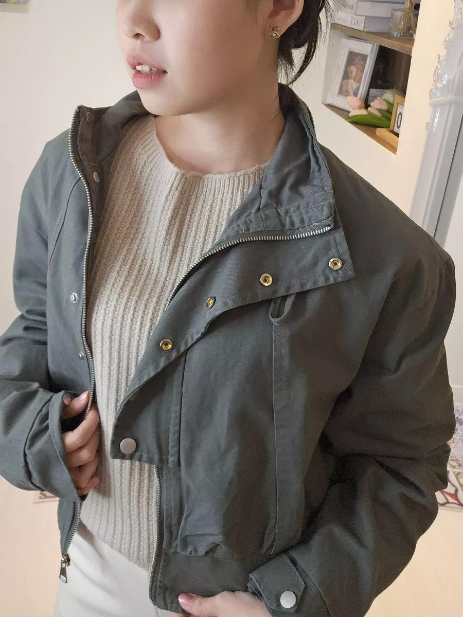 《灰影旅途》工裝立領短版夾克外套 &mdash;&mdash; 在城市的喧囂中，展開一場隨興而自由的風格冒險。 &mdash;&mdash;  【設計細節：剛柔並濟的靈魂】 =克將經典的工裝元素與現代短版廓形完美結合。 沈穩的軍綠色調（灰影綠）自帶一種不費力的時髦感，搭配領口與前襟精緻的金屬圓扣設計，在帥氣之中注入了細膩的質感。 不論是隨意敞開領口，或是全扣後的立領穿法，都能展現不同的層次張力。  【產品亮點】 黃金比例短版剪裁：短版設計，能視覺上拉高腰線，比例更顯挑高。 舒適落肩闊型： 不挑身形，消除了肩膀的沈重感，內搭厚實針織衫也依然俐落。 機能質感面料： 採用具挺度的布料，穿上即顯挺括有神，不易皺好打理，是旅途中最可靠的穿搭夥伴。  【穿搭靈感】 個性混搭： 內搭柔美的針織毛衣，運用針織與工裝布料的「剛柔對比」，層次感十足。 街頭運動： 搭配高腰寬褲與白布鞋，輕鬆穿出帥氣又顯腿長的街頭時髦。