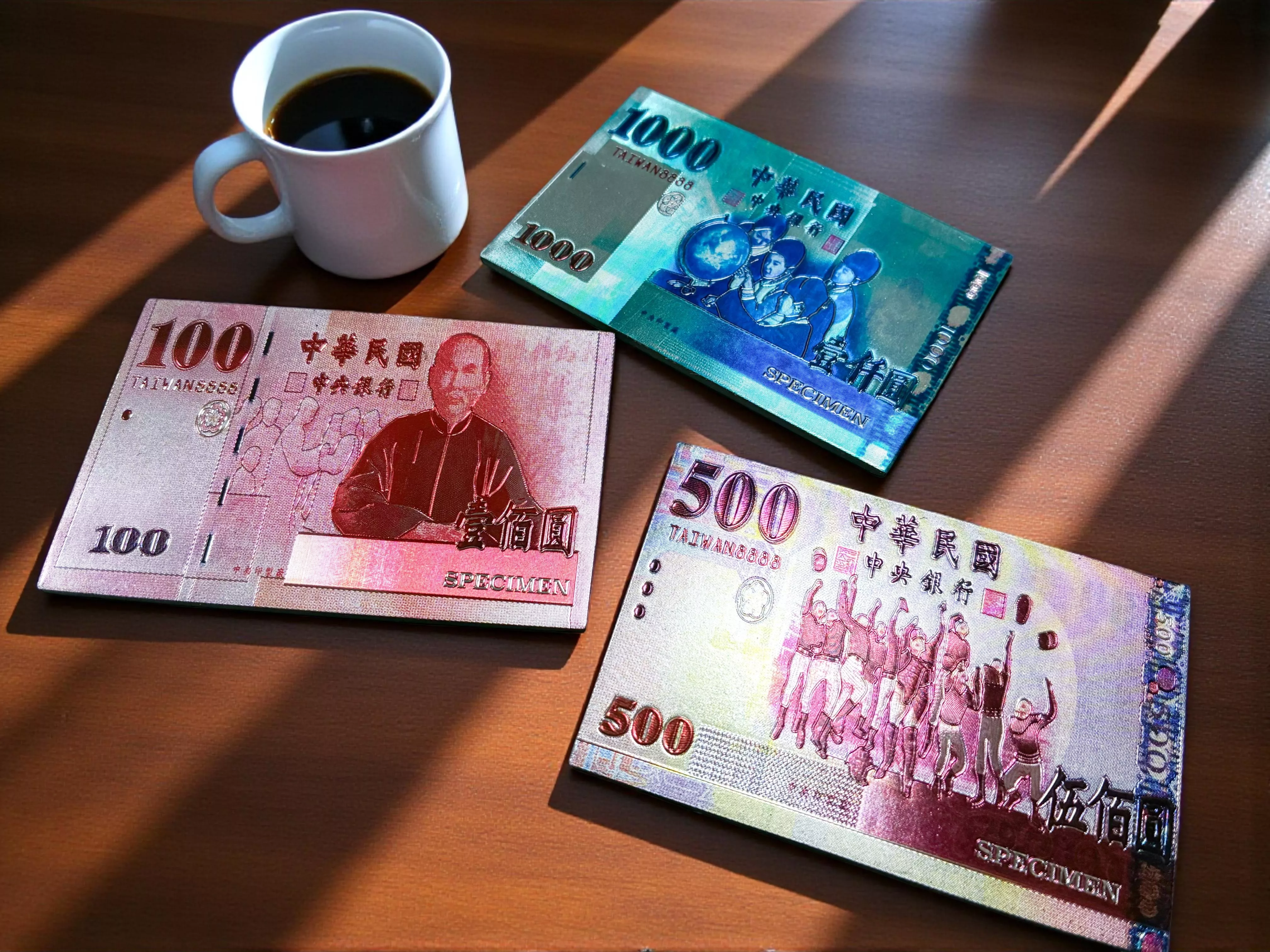 木桌上的台灣創意台幣磁鐵，象徵招財與創意辦公室裝飾。