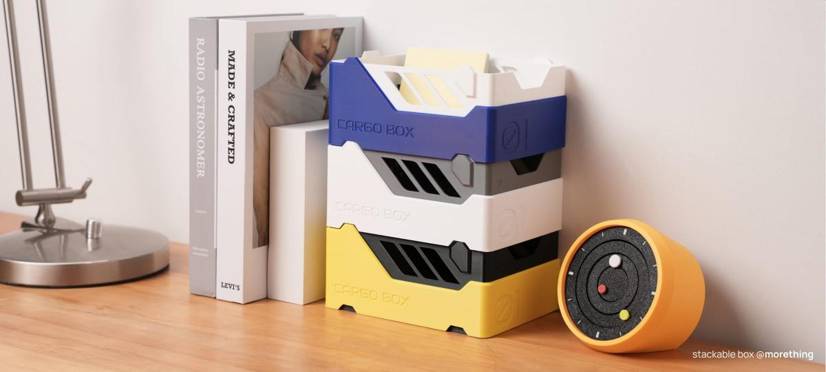 以 Bambu PETG Basic 基礎款系列線材 列印的桌上堆疊收納盒，放在書本與檯燈旁